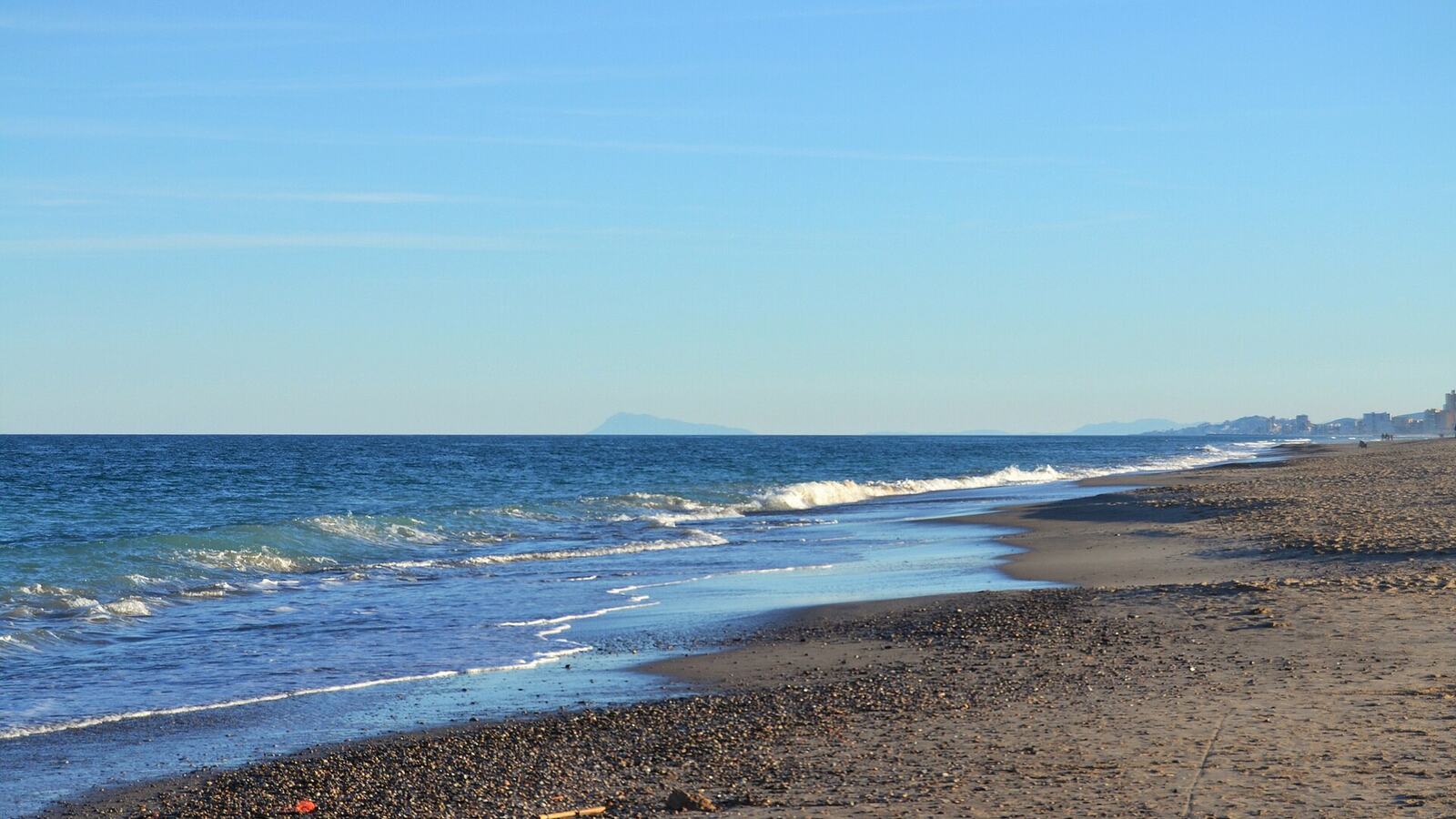 Strand van La Devesa bij Valencia met zicht op de bergen in de verte