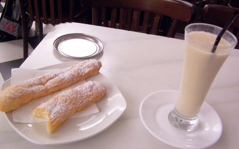Een glas horchata met twee fartons op een schoteltje