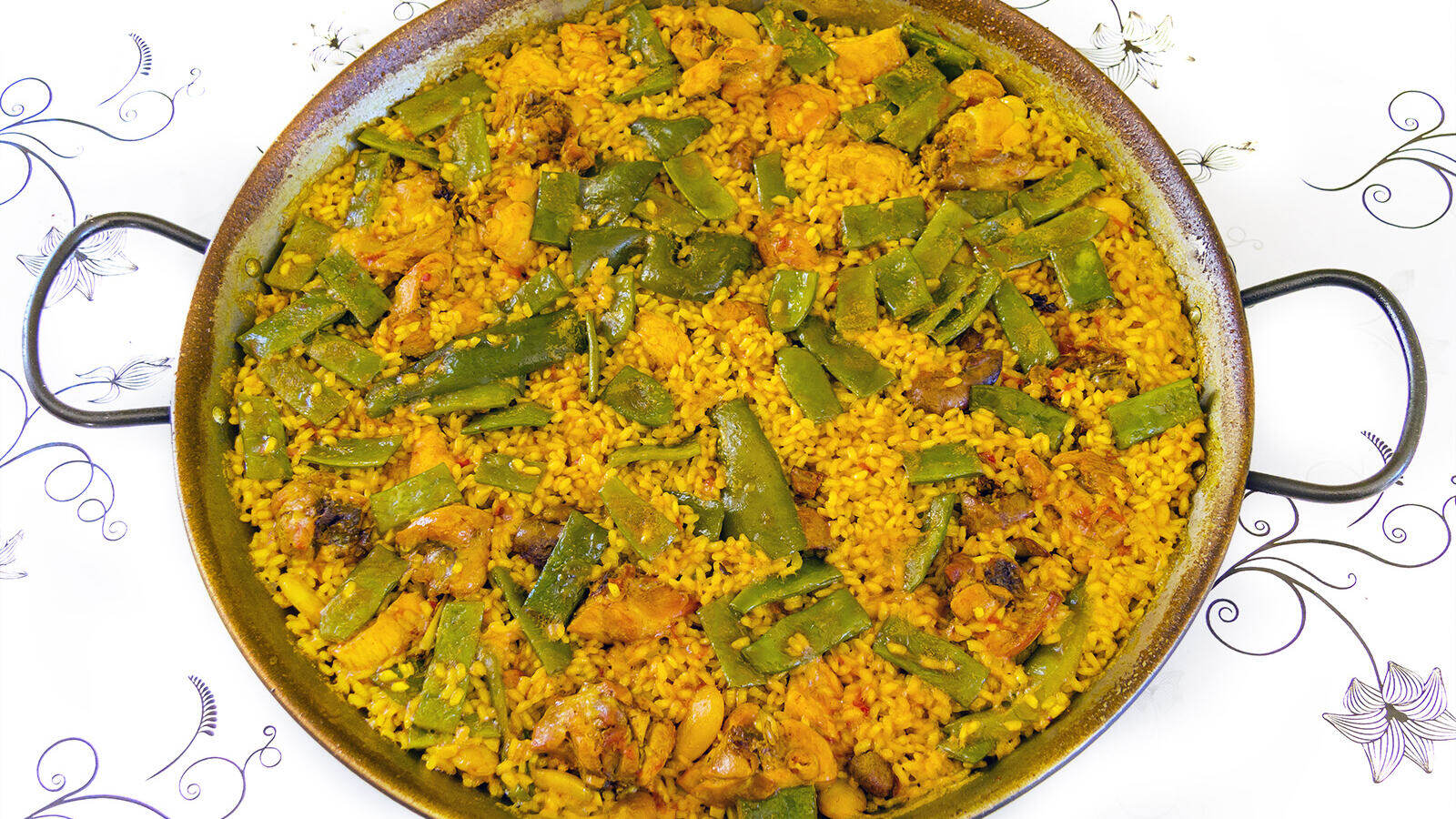 Een pan echte paella valenciana met rijst, kip, konijn en groene bonen