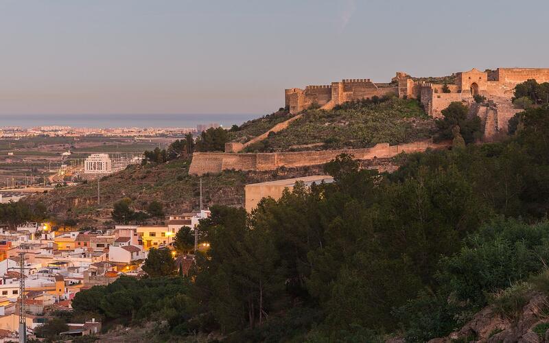 Het kasteel van Sagunto op de heuvel boven de stad bij schemering